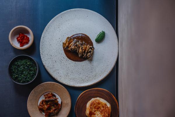 Hay smoked celeriac, black garlic curry, nettle and coconut with fried long aubergine and jaggery moju a hand-stretched buttermilk roti