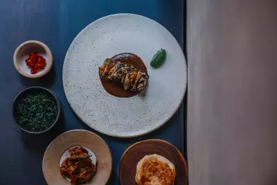Hay smoked celeriac, black garlic curry, nettle and coconut with fried long aubergine and jaggery moju a hand-stretched buttermilk roti