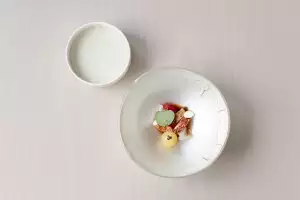 Scottish lobster with garlic caper jangajji, dongchimi, and strawberry, served with a lobster shell reduction and finished with baby artichoke foam