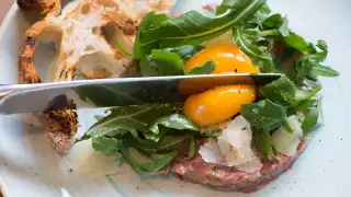 Steak tartare with egg yolk, rocket and sourdough