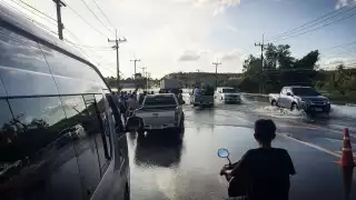 People navigate a flooded road in Trang, southern Thailand