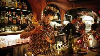 A bartender pours a drink at Bar Raval
