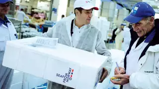 A factory worker with packaged-up fish