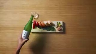 What is Sake?: Woman pouring bottle of sake for Japan Week