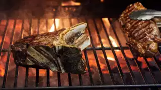 Steak cooking over flames at Goodman Mayfair