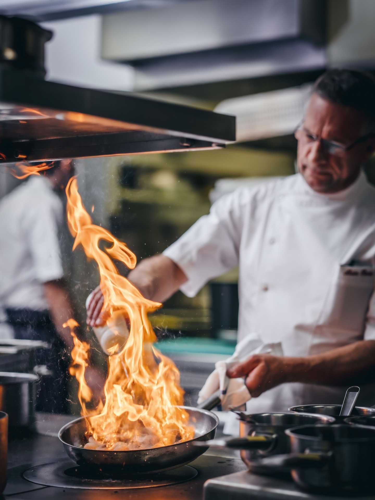 Alain flambés mushrooms in white port at service in The Waterside Inn’s kitchen