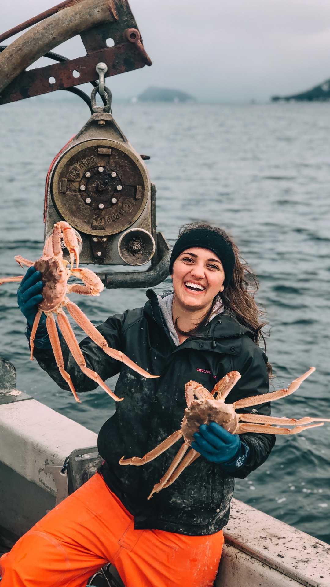 Kinsey brown holding up two Alaskan crabs