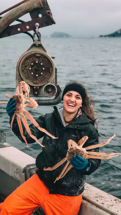 Kinsey brown holding up two Alaskan crabs