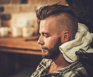 A man getting his hair cut in a distinctive skullcut style