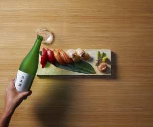 What is Sake?: Woman pouring bottle of sake for Japan Week